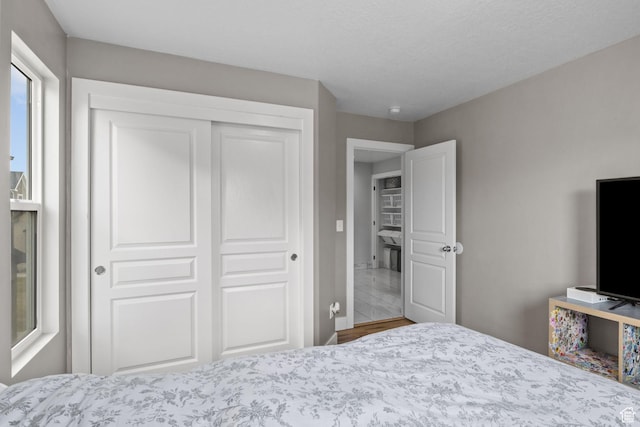 bedroom featuring a closet, baseboards, and wood finished floors