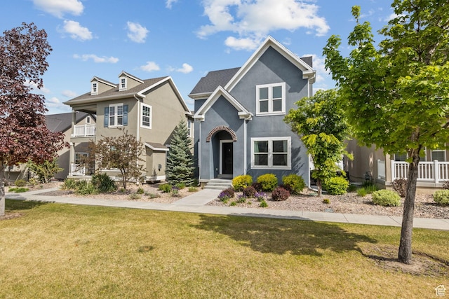 traditional-style home featuring stucco siding and a front lawn