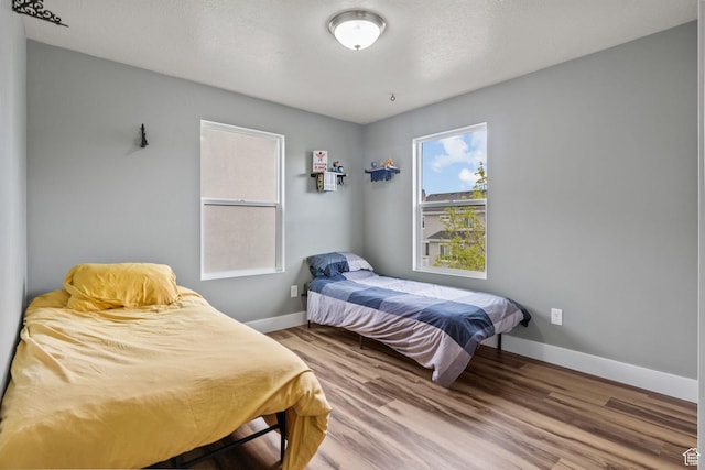 bedroom featuring wood finished floors and baseboards