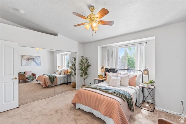 bedroom with carpet flooring, vaulted ceiling, ceiling fan, a textured ceiling, and a closet