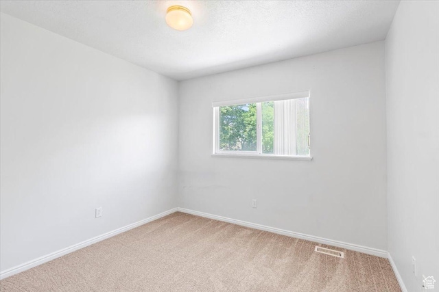 carpeted empty room with baseboards