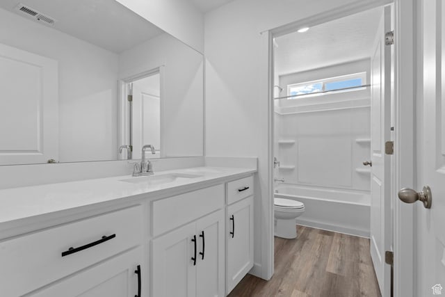 full bathroom with toilet, wood finished floors, vanity, and bathtub / shower combination