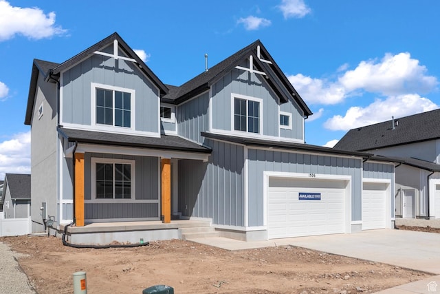 view of front of home with covered porch, driveway, board and batten siding, and a garage