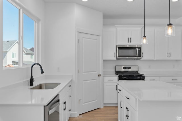kitchen featuring stainless steel appliances, a sink, healthy amount of natural light, light wood-style flooring, and recessed lighting