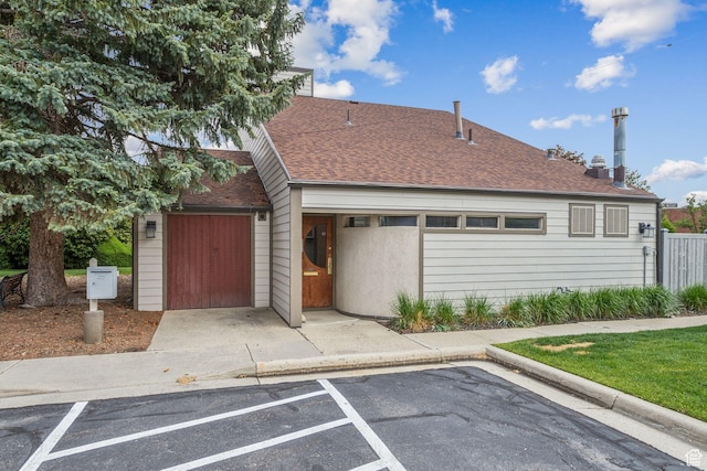 view of front of home featuring a shingled roof and uncovered parking