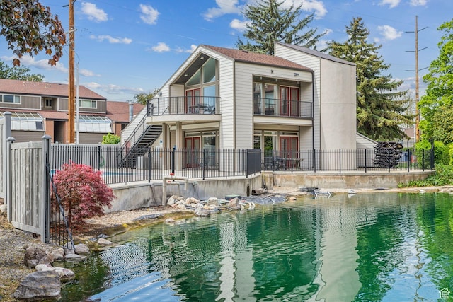 back of house with a balcony, a patio area, and stairs