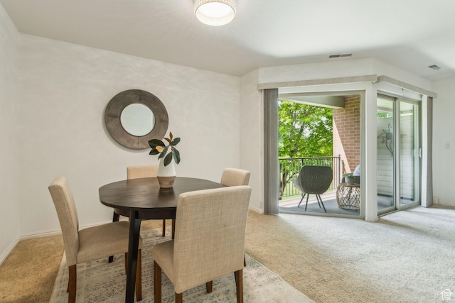 carpeted dining space featuring baseboards