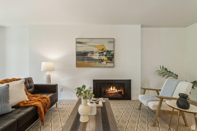 living area with a warm lit fireplace and baseboards