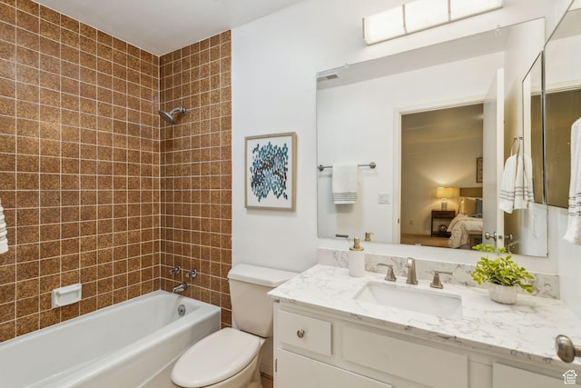 ensuite bathroom with bathtub / shower combination, toilet, and vanity