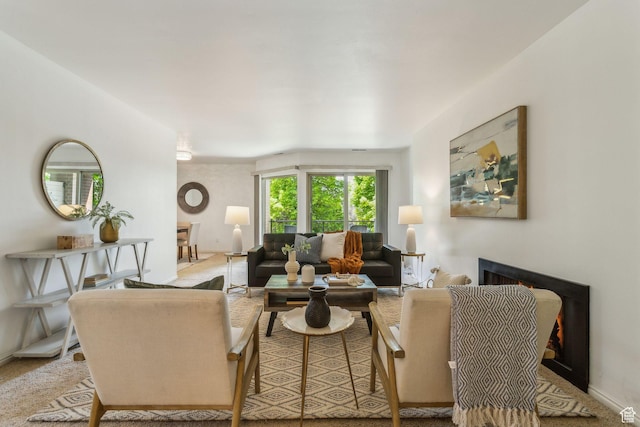 carpeted living room with a lit fireplace