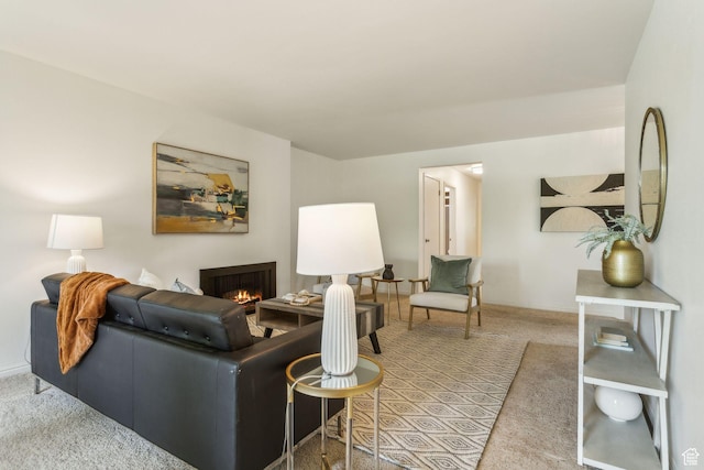 living area featuring carpet, a lit fireplace, and baseboards
