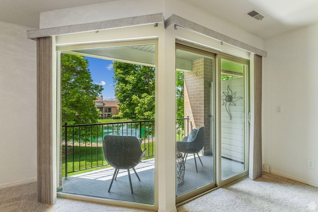 doorway to outside featuring carpet and baseboards
