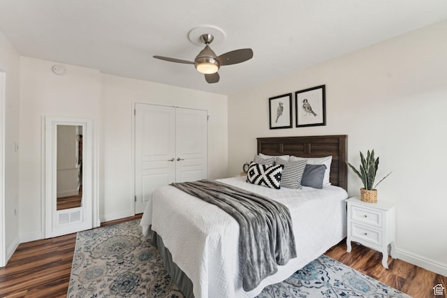 bedroom featuring dark wood-style floors, baseboards, a closet, and ceiling fan
