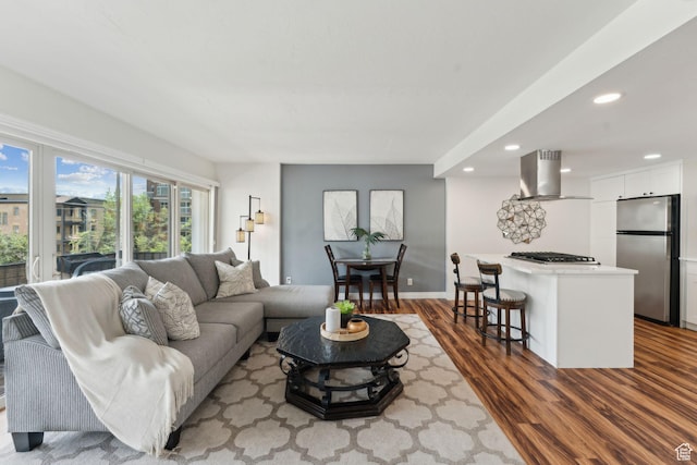 living area with wood finished floors, recessed lighting, and baseboards