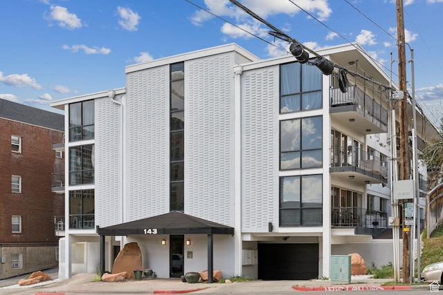 view of apartment building / complex with a garage and driveway