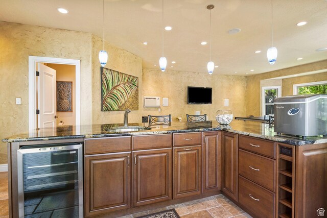 kitchen featuring wine cooler, a sink, stone tile flooring, dark stone counters, and a textured wall