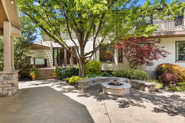 view of patio / terrace with an outdoor fire pit and a balcony