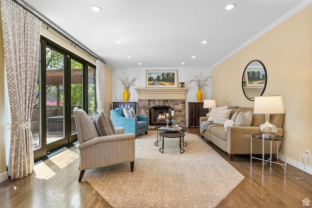living area with ornamental molding, baseboards, recessed lighting, wood finished floors, and a fireplace