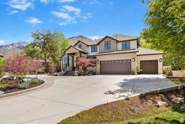 view of front of property with driveway, a mountain view, board and batten siding, an attached garage, and a garage