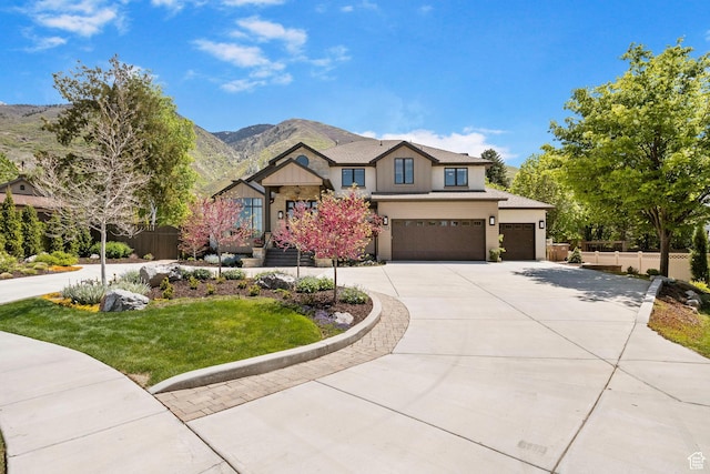 view of front of house with driveway, a mountain view, a garage, board and batten siding, and stone siding