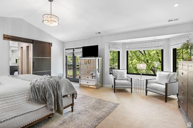 bedroom featuring a barn door, lofted ceiling, and carpet