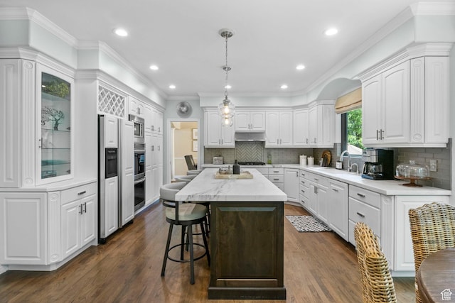 kitchen with white cabinets, dark wood-style floors, a sink, crown molding, and recessed lighting