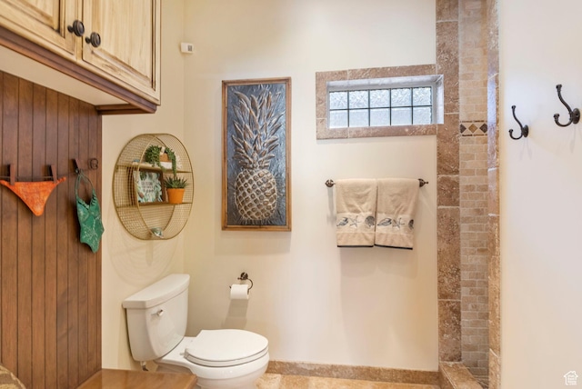 bathroom with toilet and a tile shower