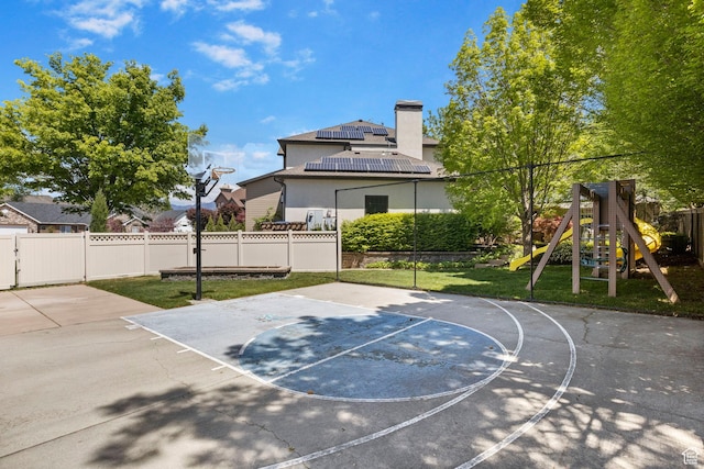 view of sport court featuring basketball hoop and a playground