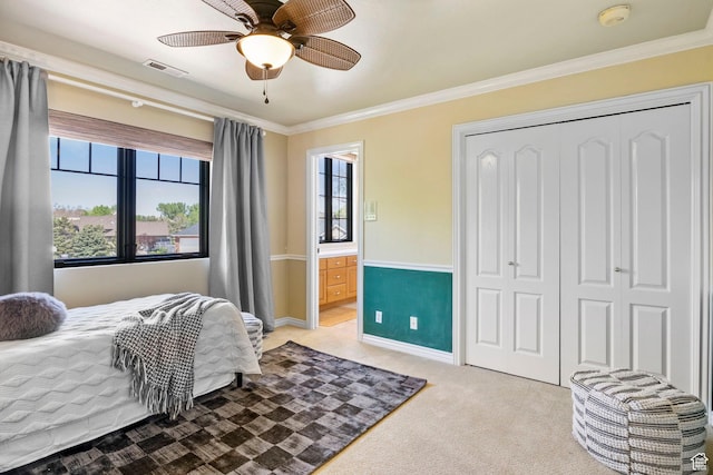 bedroom featuring light carpet, ornamental molding, a closet, connected bathroom, and baseboards