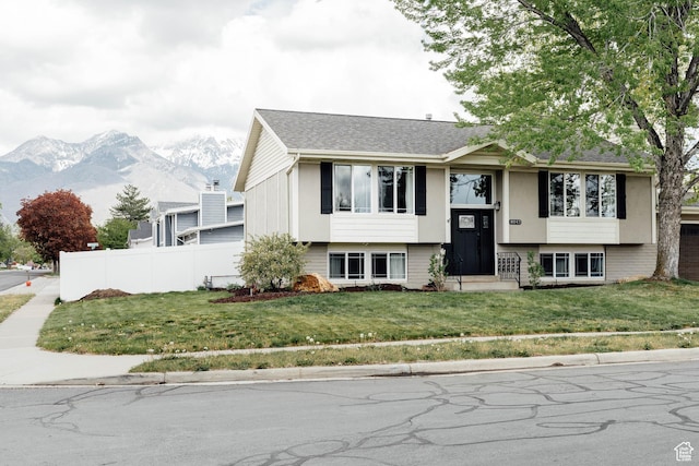raised ranch with a mountain view and roof with shingles