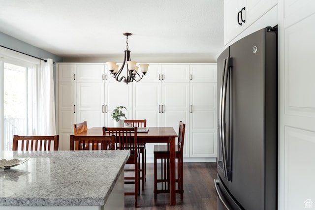 dining room with a chandelier and dark wood finished floors