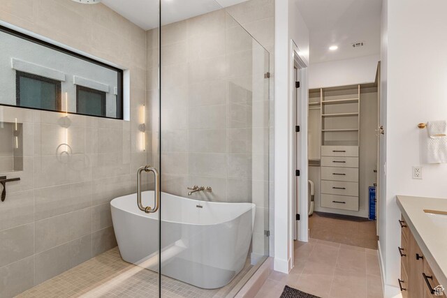 833 W Savoy Ln, St George, UT 84790 - full bath with tile patterned flooring, a walk in closet, tile walls, a soaking tub, and vanity