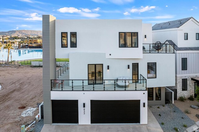 833 W Savoy Ln, St George, UT 84790 - back of house with a balcony, a mountain view, a garage, and stucco siding