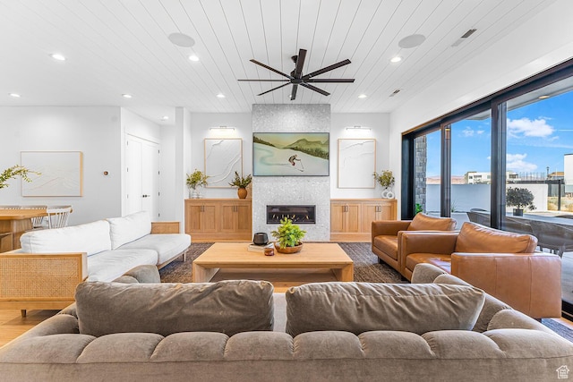 living room with ceiling fan, recessed lighting, wood finished floors, a fireplace, and wood ceiling