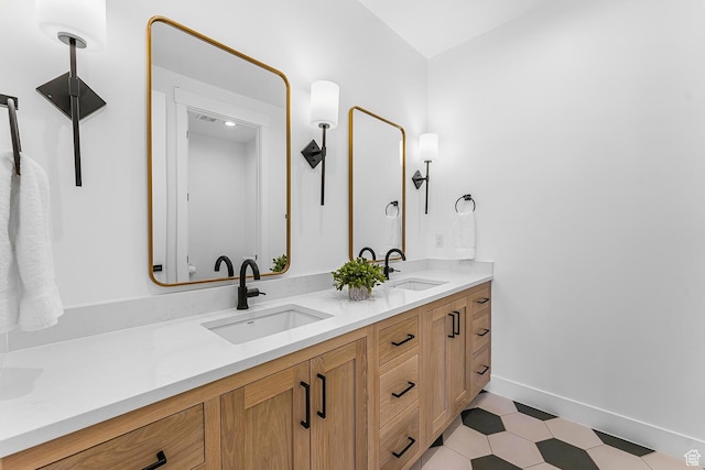 full bath with double vanity and baseboards
