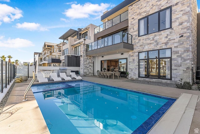 view of pool featuring fence, a patio area, and a residential view