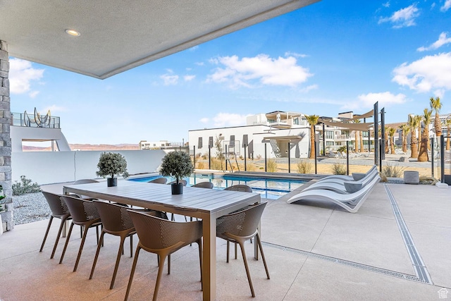 balcony with a patio area, view of pool, and outdoor dining area
