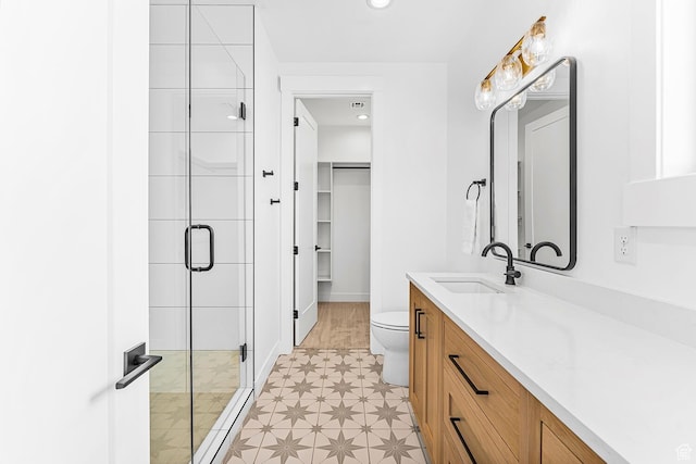 full bath featuring a shower stall, toilet, vanity, a spacious closet, and recessed lighting