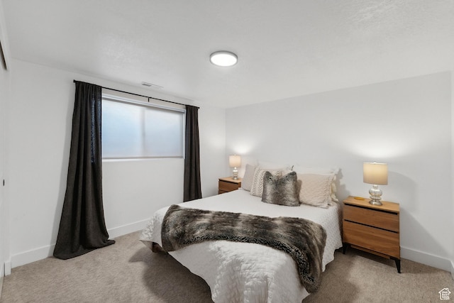 bedroom with light carpet and baseboards