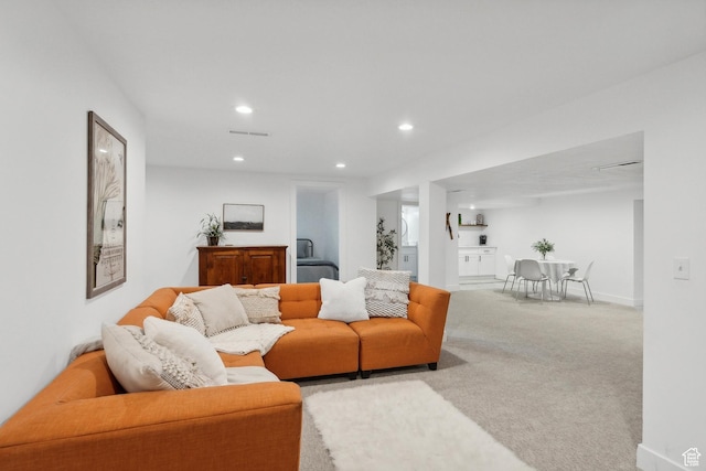 carpeted living area featuring recessed lighting and baseboards