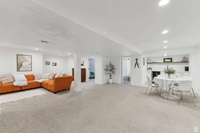 living room with bar with sink, recessed lighting, and baseboards