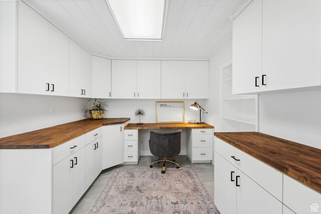home office with built in desk, light tile patterned floors, and wooden ceiling