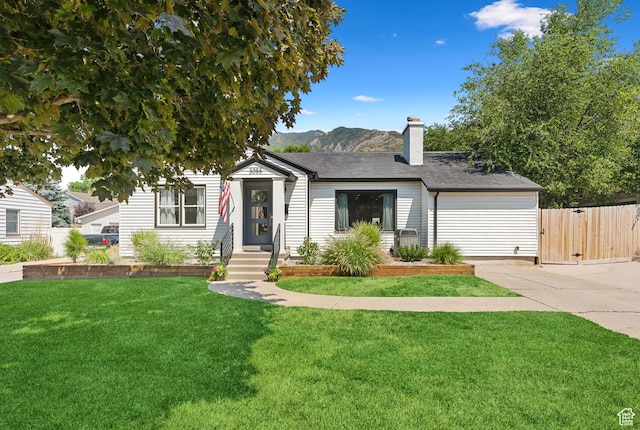 view of front of house with a chimney, concrete driveway, and a mountain view