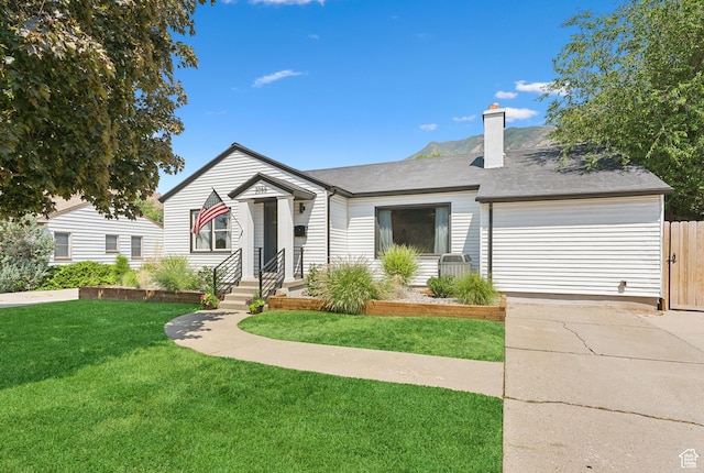 view of front of home with concrete driveway, a garage, and a chimney