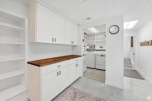 kitchen featuring washer and dryer, wooden counters, white cabinetry, and built in features