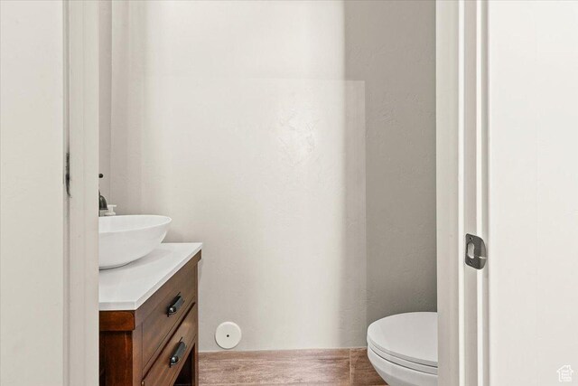 half bathroom featuring vanity and toilet