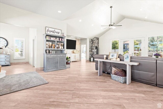 living area with a ceiling fan, high vaulted ceiling, light wood-style floors, recessed lighting, and french doors
