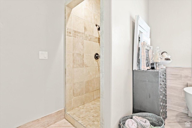 full bath with a tile shower and a freestanding bath