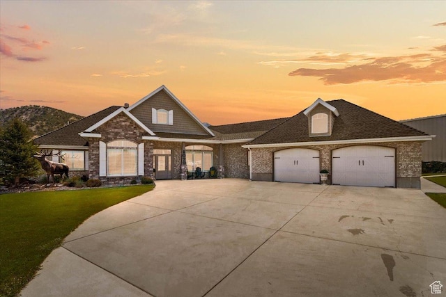 view of front facade with a front lawn, concrete driveway, an attached garage, and brick siding