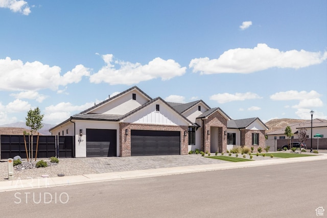 657 E Royal Dr, Washington, UT 84780 - view of front of house with brick siding, a garage, decorative driveway, and board and batten siding